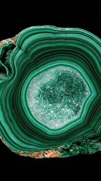 Close-up of vibrant green malachite stone with concentric banding and crystal geode center