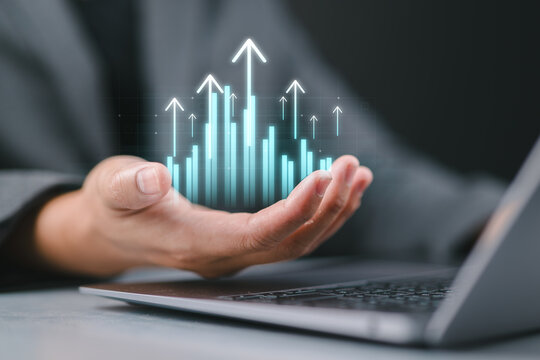 Business growth concept, businessman using laptop, hand holding digital graph and chart and arrow pointing upwards, finance and investment, banking, data analysis and digital transformation.
