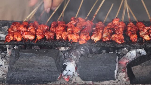 Grilling satay over hot charcoal flames, creating delicious smoky traditional cuisine.