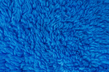 Blue curly fleece fabric texture background in macro close up © Iryna Miadzvedzeva