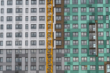 Colors and textures blend on a modern building facade under construction in a busy urban area © beholdereye