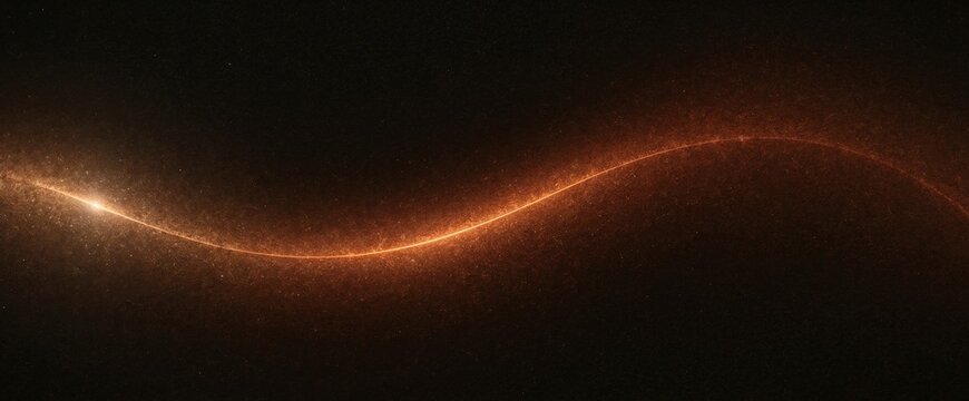 Glowing orange dust particles forming a soft curved wave trail against dark background with orange light