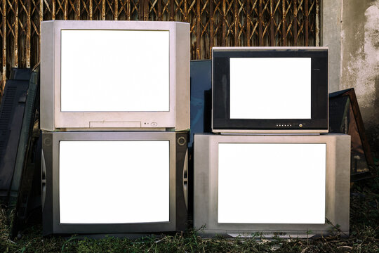 Vintage, old CRT televisions stacked outdoors, with blank white screen, Obsolete electronic devices, e-waste.