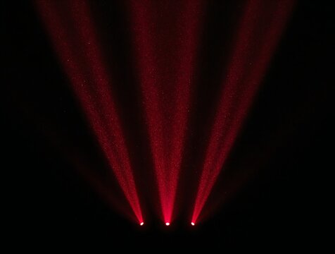 Three distinct red light beams shining down into darkness with dust particles light rays dark background red glow