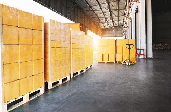 bulk of package boxes shipment. goods awaiting loading into containers truck. forklift pallet jack loader. distribution warehouse shipping, cargo shipment. freight transportation logistics	
