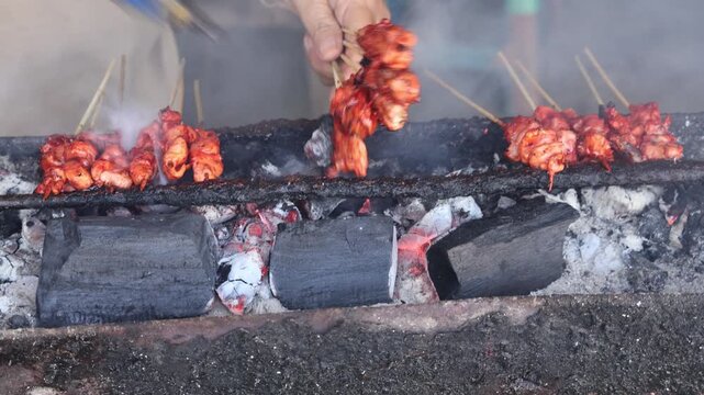 Grilling satay over hot charcoal flames, creating delicious smoky traditional cuisine.