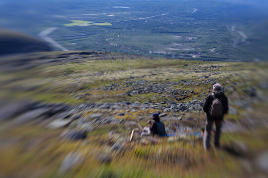 Hikers on mountain slope photographed with tilt-shift effect in Khibiny Mountains, Russia