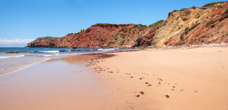 red sandstone cliff Amado beach, fine sandy bathing area. algarve coastal landscape