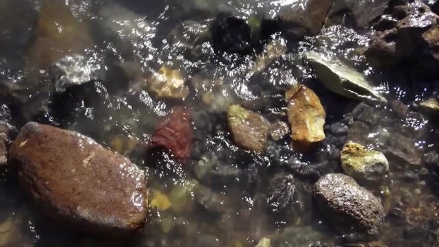 A professional stock footage featuring stream bed rocks captured in high definition, perfect for commercial projects, travel documentaries, and background