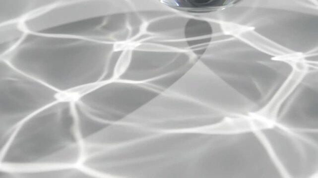 Abstract water caustics background, shimmering light reflections on gray surface, ripple effect texture for spa and wellness