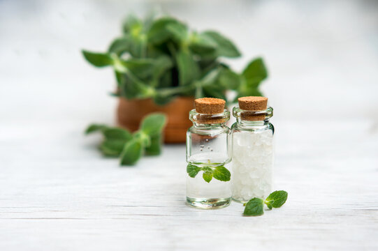 Spa and wellness setting with sea salt, oil essence, jasmin flowers and towels on wooden background. Relax and treatment therapy.