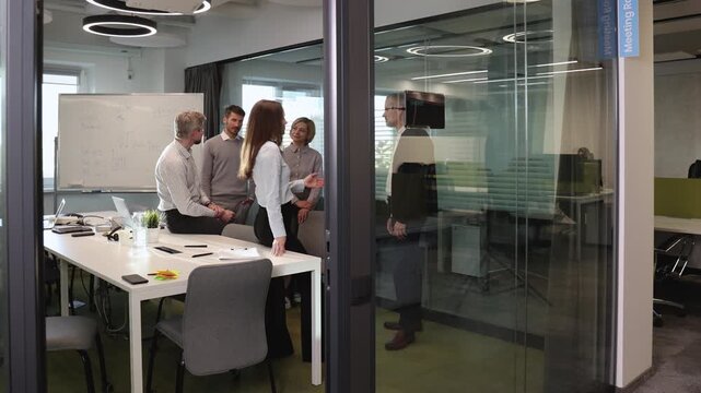 Creative business people, planning and meeting and brainstorming, ideas or strategy at office, view from glass wall.