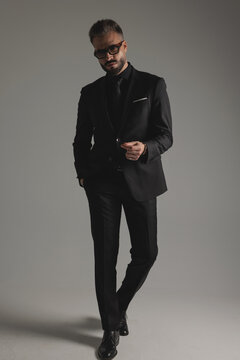 Elegant man in suit walking and looking forward