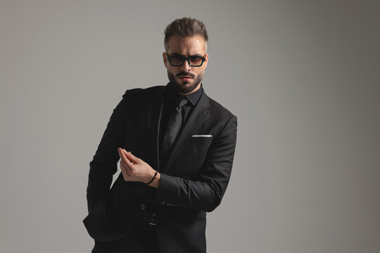 Serious man in black suit gesturing and looking forward