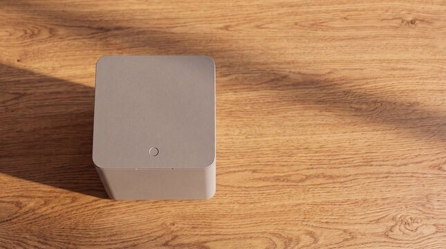 High angle top view of minimalist cube shaped smart kitchen appliance on oak wood surface
