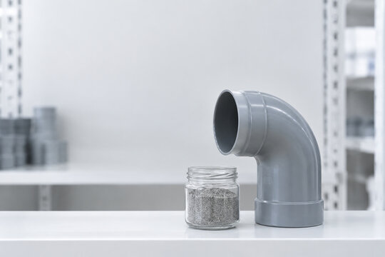 Gray drainage pipe elbow with sediment jar, plumbing and home maintenance concept