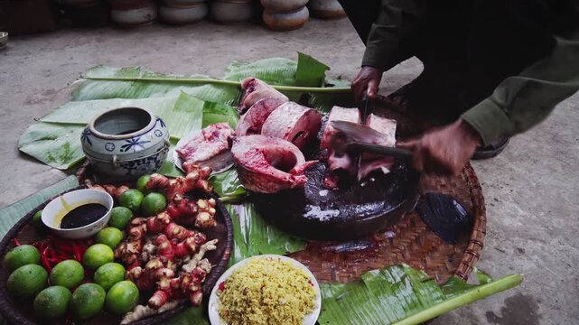 Traditional fish preparation in Vu Dai village, Ninh Binh, Vietnam, with fresh fish, limes, galangal, spices, banana leaves, and handmade cooking utensils.