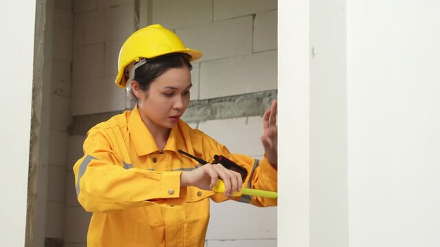 Female construction inspector reviewing a checklist at an indoor building site, ensuring safety, quality control and construction compliance.