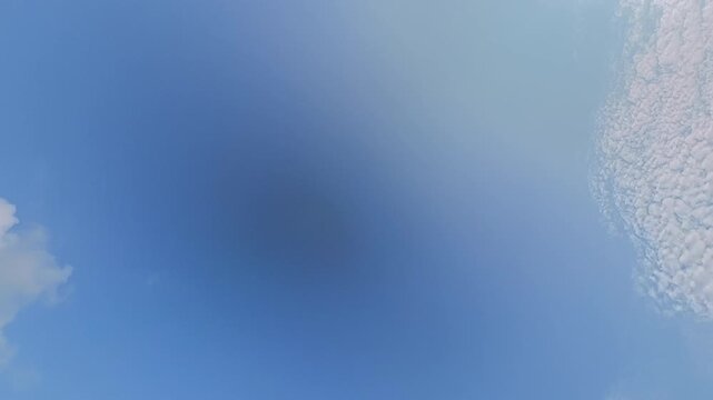 Timelapse of white clouds moving across a clear blue sky, creating a dynamic natural background for weather, nature, travel and atmospheric concepts.