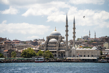 Traditional stone mosque with large domes and twin minarets overlooking the Bosphorus strait in Istanbul. Cultural heritage landmark representing historic architecture and travel exploration. © Tetiana