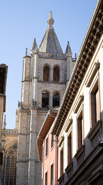 Torre de piedra de catedral g&oacute;tica vista desde una calle con edificios en Le&oacute;n, Espa&ntilde;a