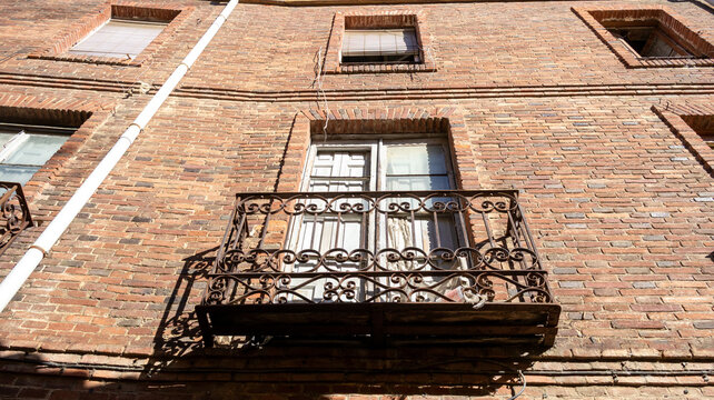 Fachada de ladrillo con balcones de forja en plano contrapicado