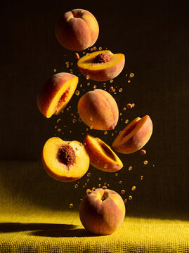 Dynamic commercial levitation photography featuring fresh fruits slices and water droplets freezing mid-air over a bright yellow textured surface with dramatic studio side lighting.