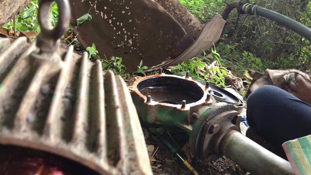 Green Centrifugal Water Pump Housing and Copper-Wound Motor Stator Core Displayed on the Ground During a Field Breakdown Maintenance and Mechanical Overhaul Operation Outdoors