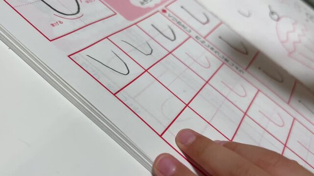 文字を書く練習をする子供の手