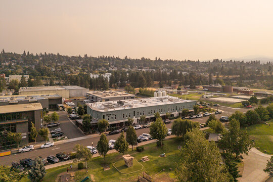 Hood River, Oregon, United States - 13 August 2026: Aerial view of pFriem Family Brewers beneath orange wildfire haze reducing visibility across the surrounding hills.