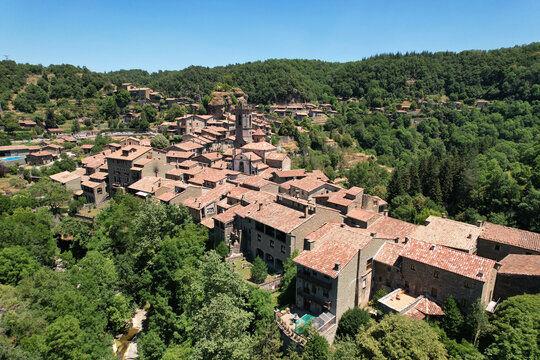 Drone view of Rupit, a picturesque medieval stone village nestled in a lush green valley in the Collsacabra natural area on sunny summer day. Catalonia, Spain.