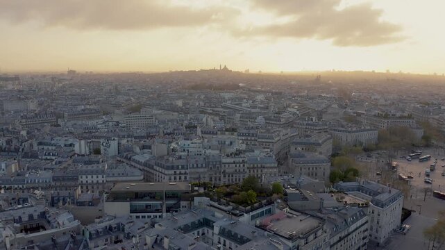 Aerial view of Paris cityscape at sunset with dense historic rooftops under a golden sky in Paris, Ile-de-France, France.