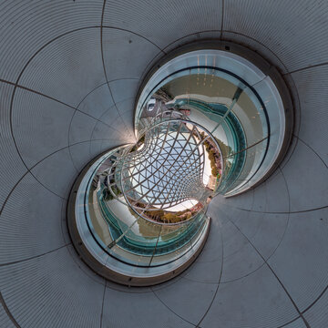 creative tiny planet photo of a rural landscape with dirt road, green fields, and cloudy sky forming a circular world.