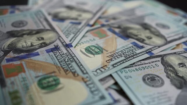 hundred dollar bills falling on spinning table in a pile of cash a heap of money