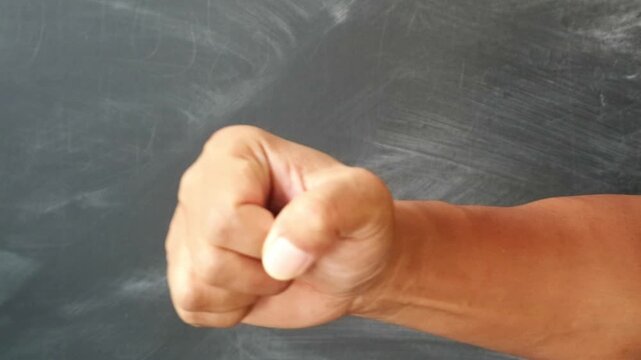 A close up view of a human hand making a tight fist gesture.