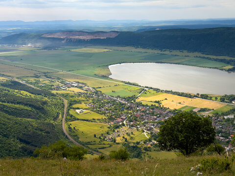Panoramic vista of Hrhov village, railway, farmlands, and Hrhovsk&eacute; rybn&iacute;ky pond from the slopes of Slovak Karst, Slovakia.