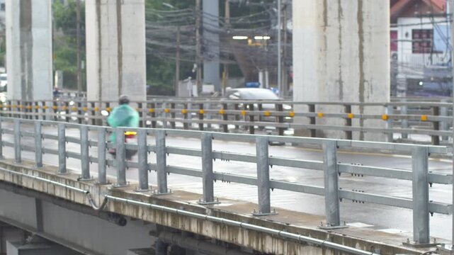 Blurred Motorcycle Speeding Under Wet Guardrail Bridge, Caution on Slippery Rain-Soaked Road Concept