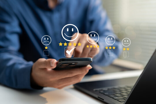Business professional using smartphone with customer satisfaction rating and five star feedback interface, illustrating positive review, service quality, user experience and online reputation.