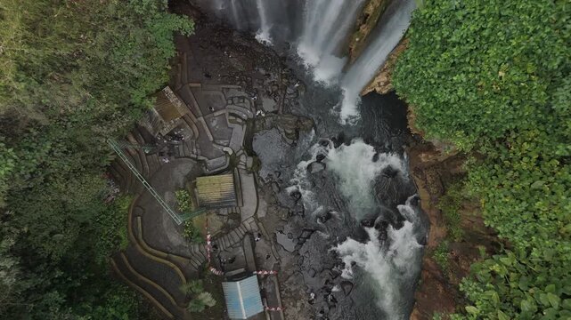 A Stunning Aerial View of a Serene Waterfall Surrounded by Lush Greenery and Rock Formations