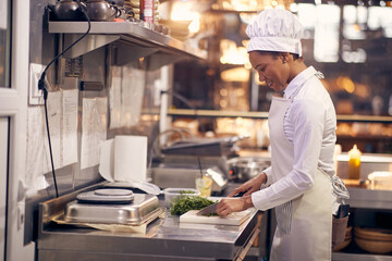 smiling chef preparing prasley for later. Cook in Professional Modern  kitchen, restaurant concept