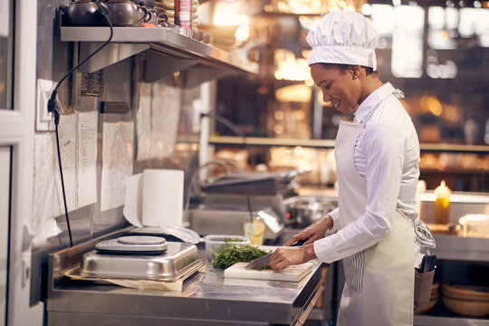 smiling chef preparing prasley for later. Cook in Professional Modern  kitchen, restaurant concept