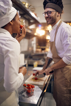 Cook in Professional Modern  kitchen, restaurant concept. Chef preparing tomatoes with colleague