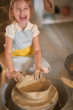 smiling shcoolgirl making clay pot on class of  art. creativity , hobby ,workshop  concept