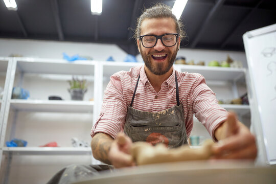 happy man making his pot from clay on pottery workshop class.  Creative, hobby ,activities concept