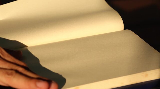 Close Up Person Flipping Blank Pages of Vintage Book in Sunlight