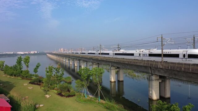 Scenic concrete railway bridge over river with park