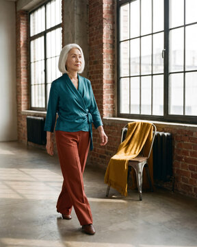Elegant mature woman standing at storefront doorway wrapped in wool scarf