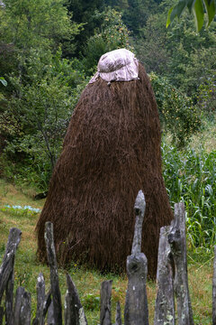 Rustic Haystack Behind Weathered Wooden Fence in Countryside Meadow