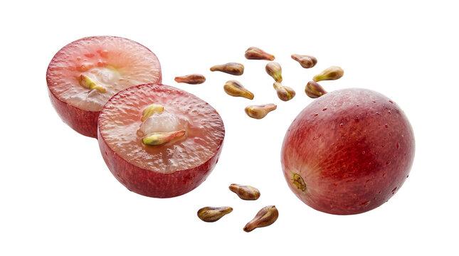 Red grape halves and grape seeds lie on a transparent background alongside a whole berry.