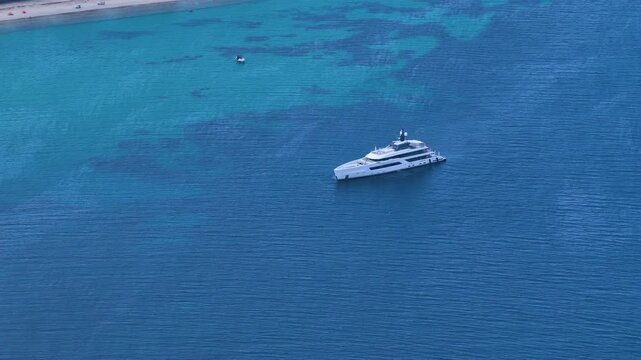 Glarokavos Beach white yacht resting on turquoise coastal waters